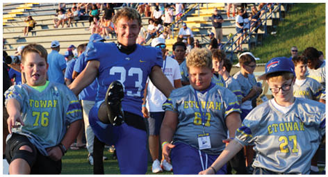 A group of football players on a field. Description generated by AI