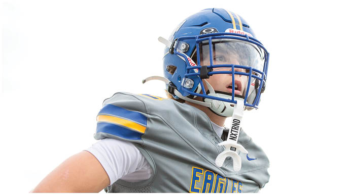 A football player wearing a blue and white uniform. Description generated by AI