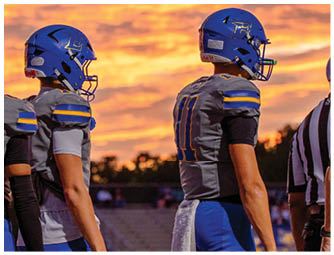 A group of football players on a field. Description generated by AI