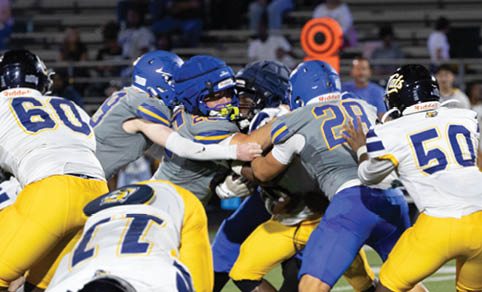 Two men wearing football uniforms are hugging each other on a field. AI generated content