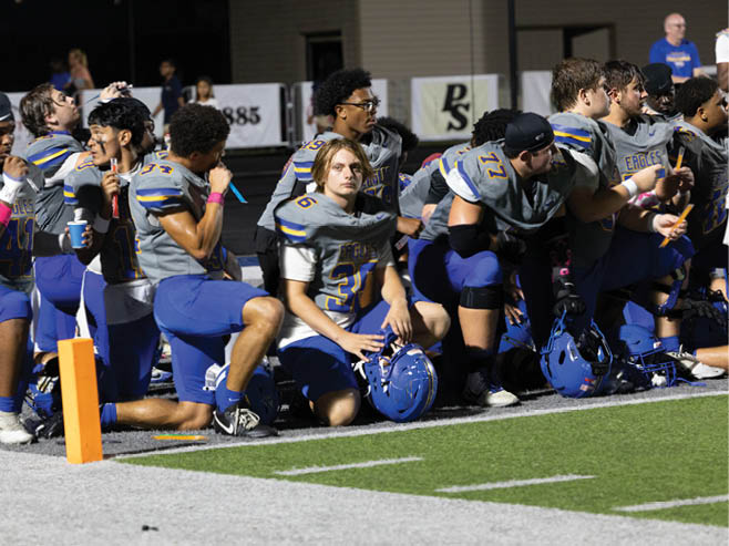 A group of football players in black and white uniforms are on the field. AI generated content