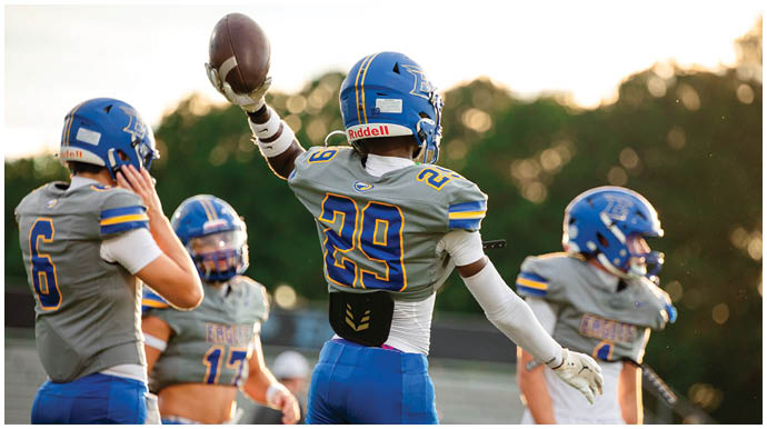 A football player wearing a blue and white uniform. Description generated by AI