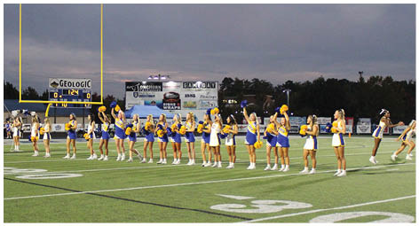 A group of football players on a field. Description generated by AI
