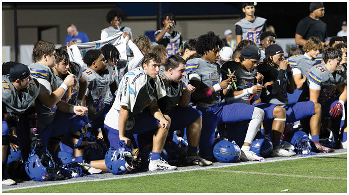 A football player wearing a blue and white uniform. Description generated by AI