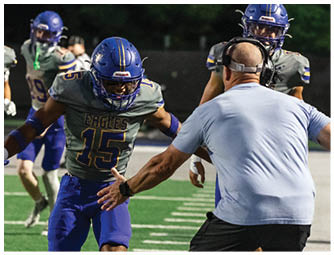 A group of football players on a field. Description generated by AI