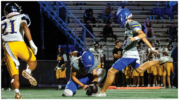 A football player wearing a blue and white uniform. Description generated by AI