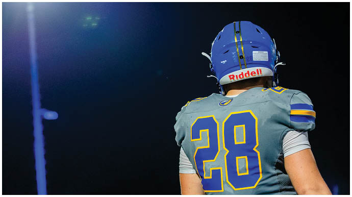 A football player wearing a blue and white uniform. Description generated by AI
