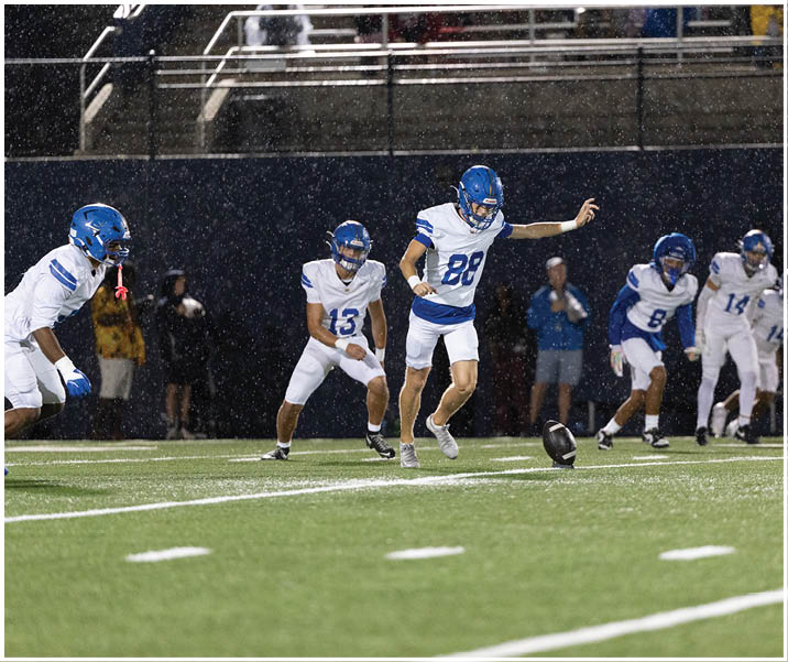 A group of football players wearing black and white uniforms. Description generated by AI