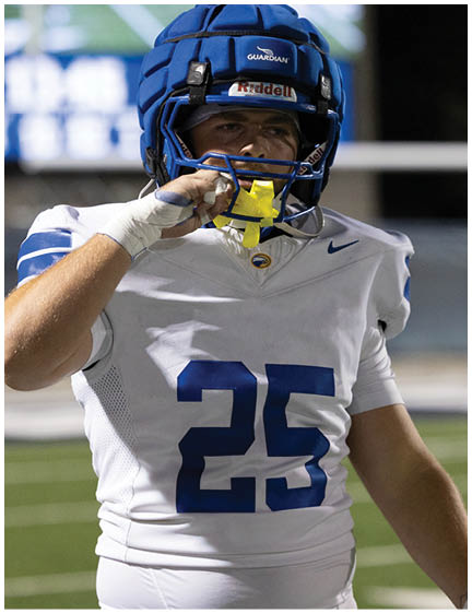 A football player wearing a blue jersey with the number 58 on it. Description generated by AI