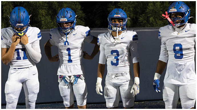 A football player wearing a blue and white uniform. Description generated by AI