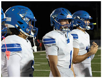 A group of football players on a field. Description generated by AI