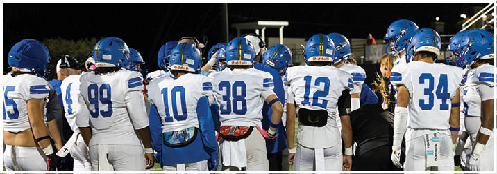 A group of football players on a field. Description generated by AI