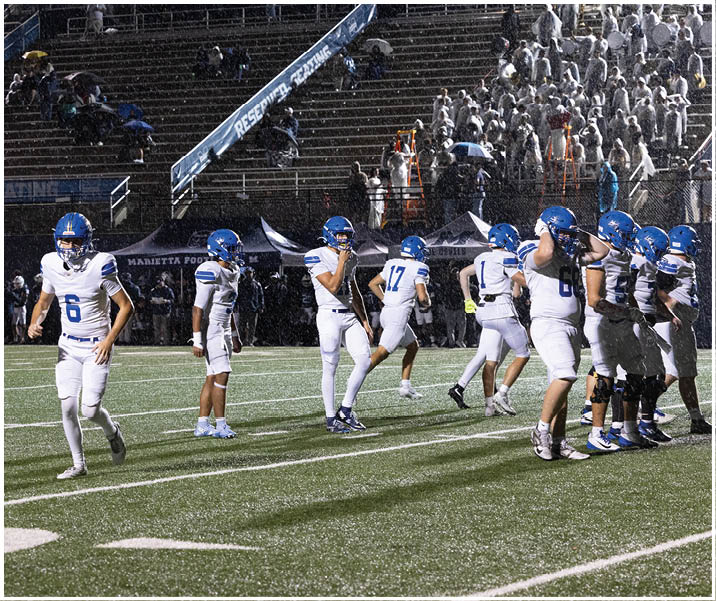 A group of football players wearing black and white uniforms. Description generated by AI