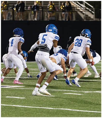 A group of football players wearing black and white uniforms. Description generated by AI