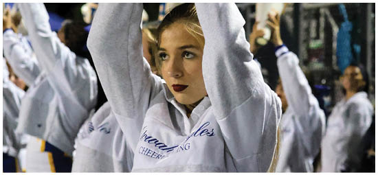 A football player wearing a blue and white uniform. Description generated by AI