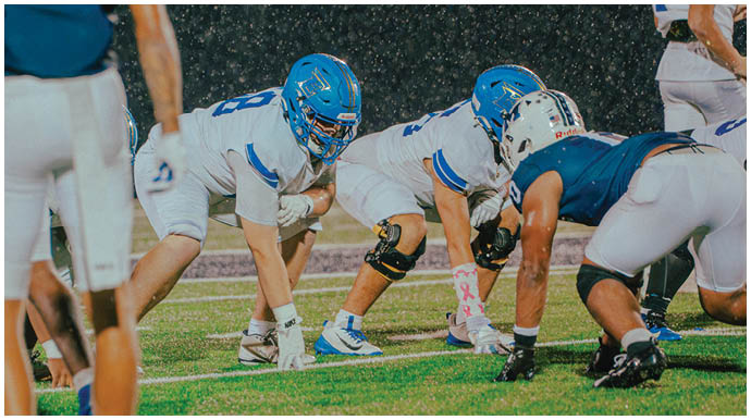 A football player wearing a blue and white uniform. Description generated by AI