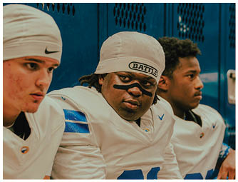 A group of football players on a field. Description generated by AI