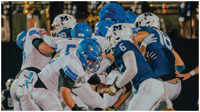 A football player wearing a blue and white uniform. Description generated by AI