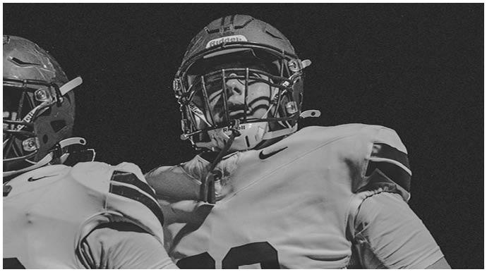 A football player wearing a blue and white uniform. Description generated by AI