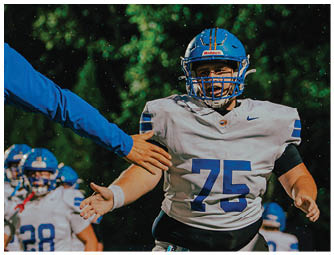 A group of football players on a field. Description generated by AI