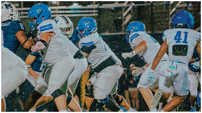 A football player wearing a blue and white uniform. Description generated by AI