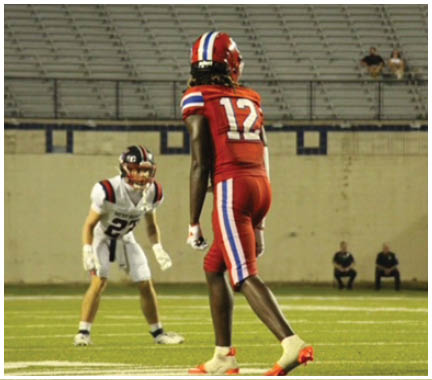 A football player wearing a blue and white uniform. Description generated by AI