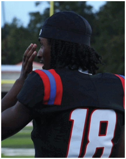 A football player wearing a blue and white uniform. Description generated by AI