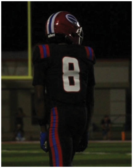 A football player wearing a blue and white uniform. Description generated by AI