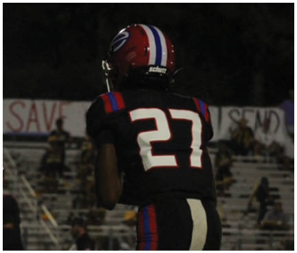 A football player wearing a blue and white uniform. Description generated by AI