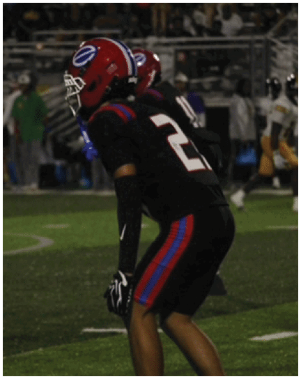 A football player wearing a blue and white uniform. Description generated by AI