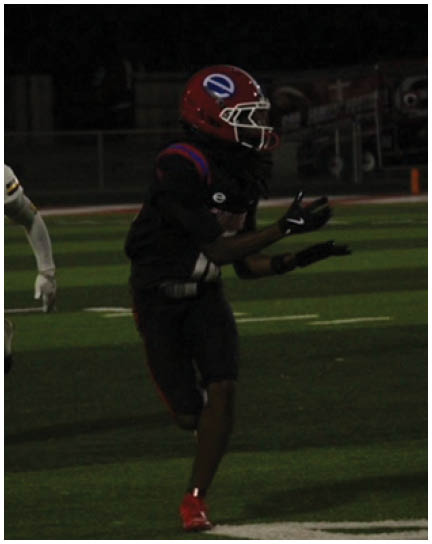 A football player wearing a blue and white uniform. Description generated by AI