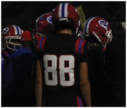 A football player wearing a blue and white uniform. Description generated by AI