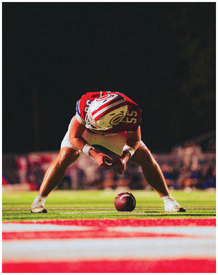 A football player wearing a blue and white uniform. Description generated by AI