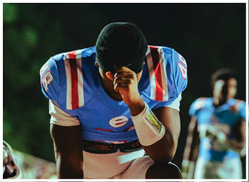 A football player is sliding on the ground. Description generated by AI