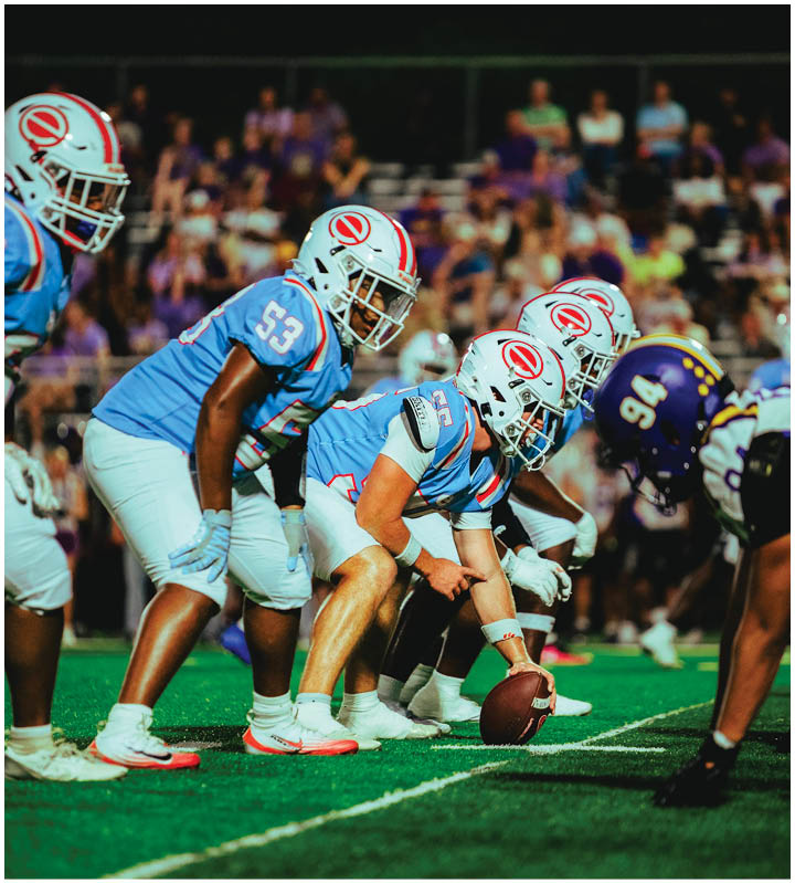 A group of football players wearing black and white uniforms. Description generated by AI