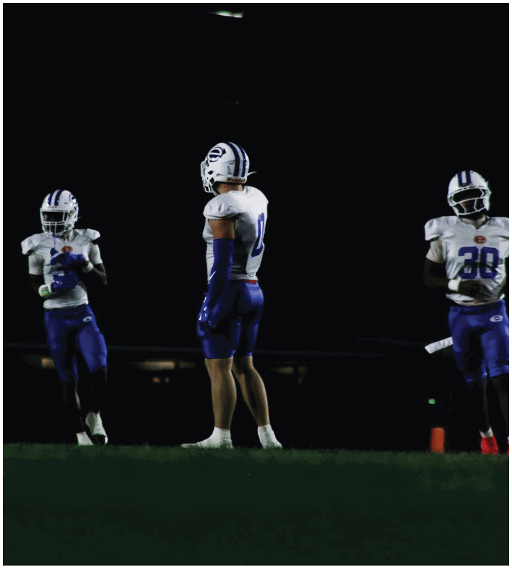 A group of football players wearing black and white uniforms. Description generated by AI