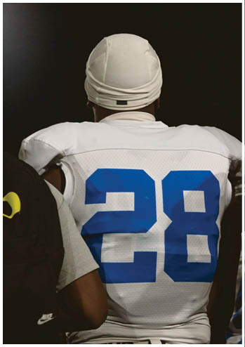 A football player running on the field. Description generated by AI
