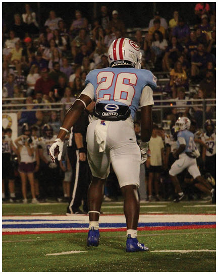 A football player wearing a blue and white uniform. Description generated by AI