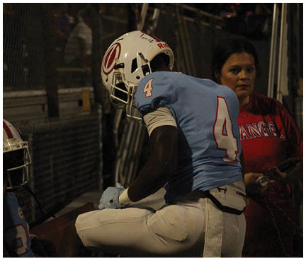 A football player wearing a blue and white uniform. Description generated by AI