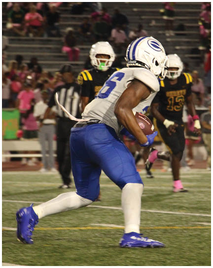 A football player wearing a blue and white uniform. Description generated by AI