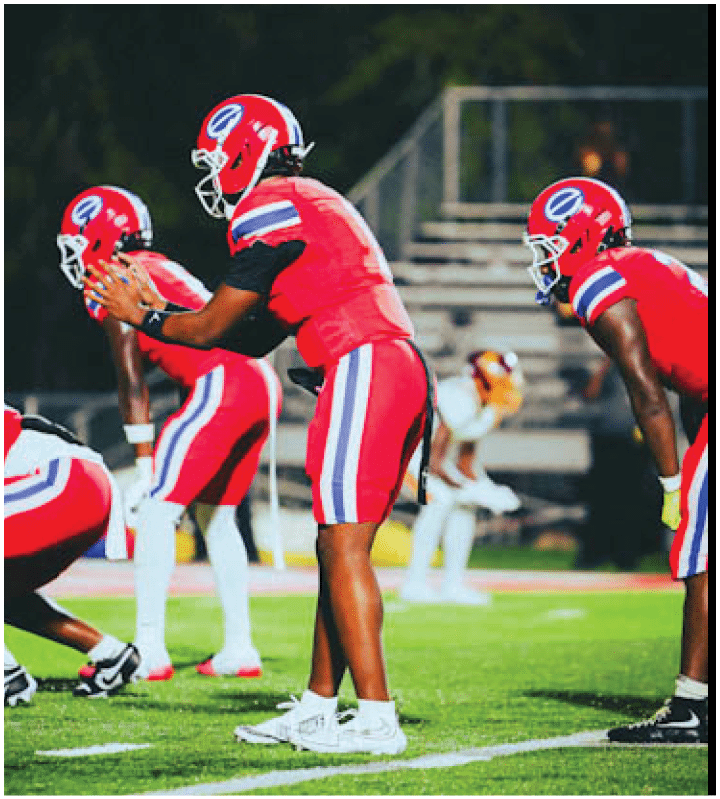 A group of football players wearing black and white uniforms. Description generated by AI