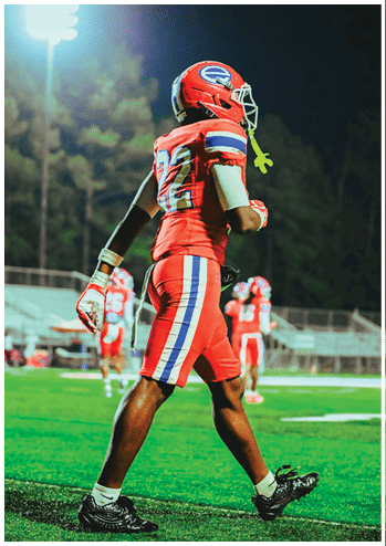 A football player running on the field. Description generated by AI