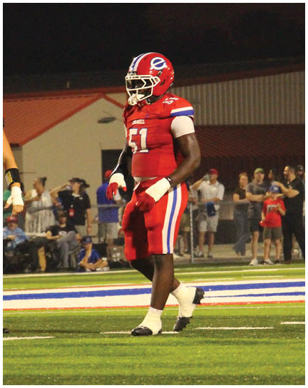A football player wearing a blue and white uniform. Description generated by AI