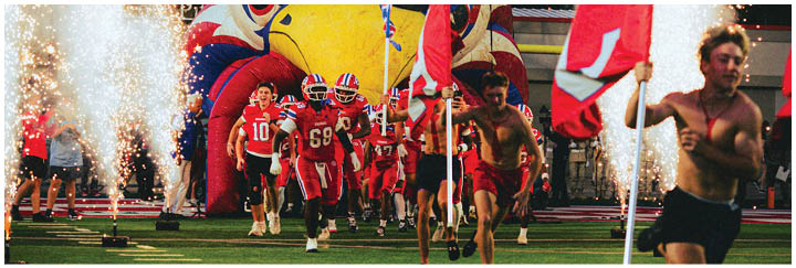 A group of football players on a field. Description generated by AI