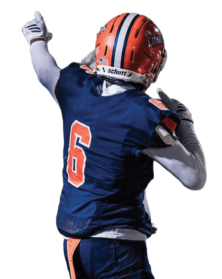 A person wearing a blue and orange football uniform with the number six on the back is standing on a field pointing upward. Description generated by AI