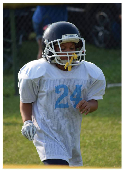 Two football players wearing black jerseys and holding hands. Description generated by AI