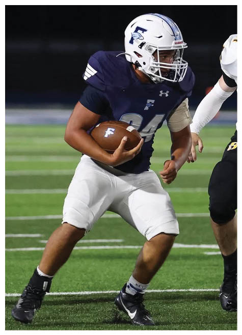 Two football players wearing black jerseys and holding hands. Description generated by AI