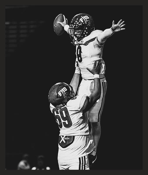A football player in a white uniform is running with a football in his hand. AI generated content