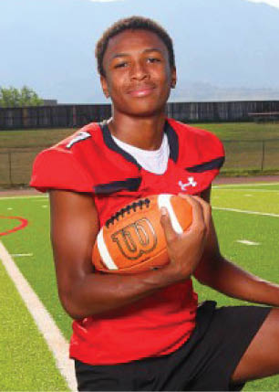 A young man wearing a white and black jersey with the number 14 on it. Description generated by AI
