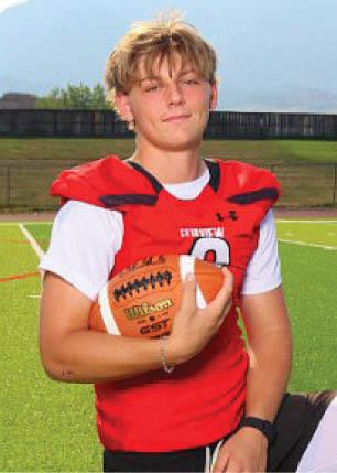 A young man wearing a white and black jersey with the number 14 on it. Description generated by AI